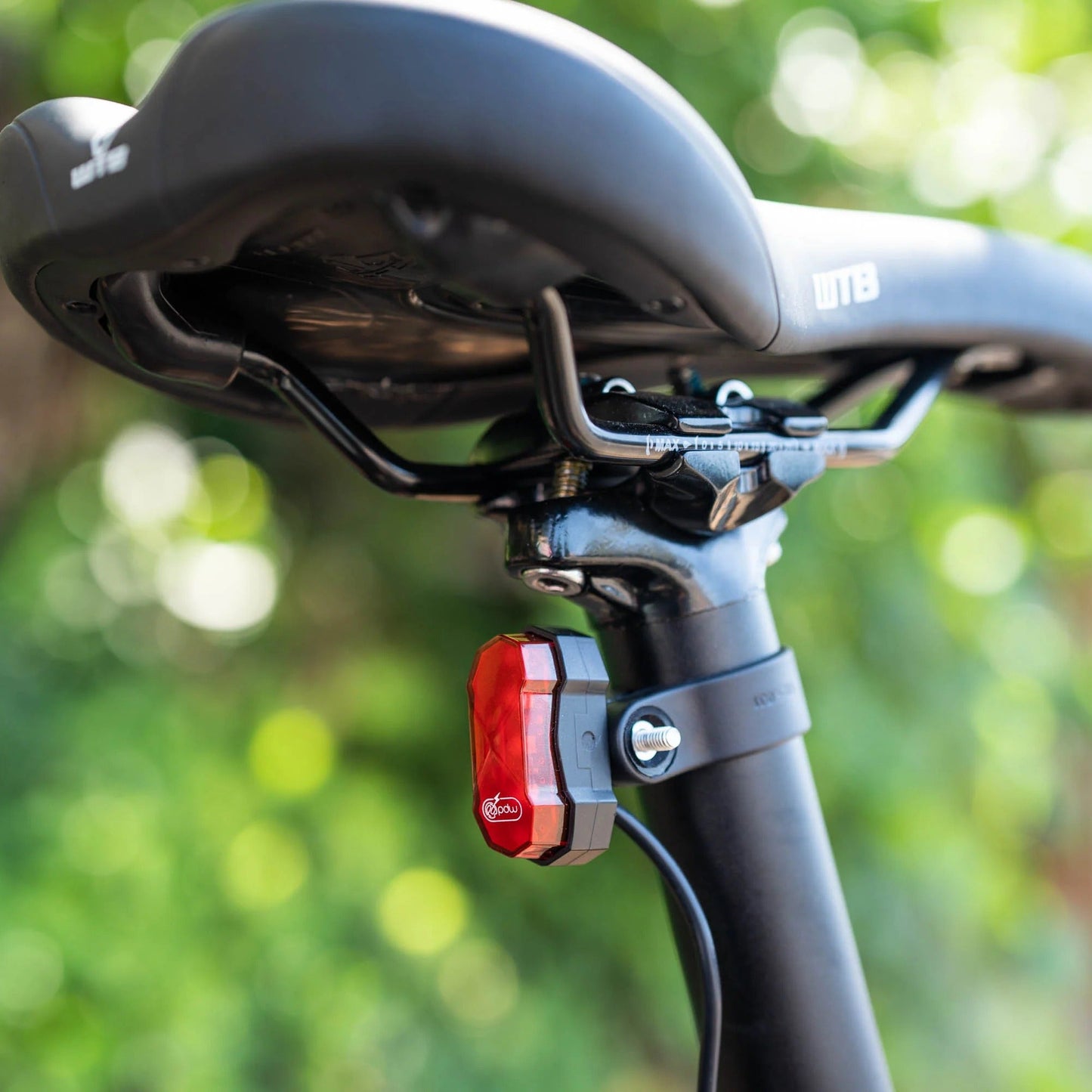 Bicycle seat with a red and white light on a blurred green background
