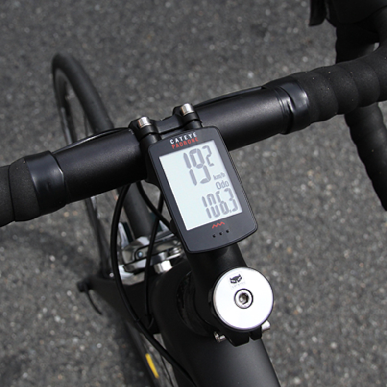 Bicycle handlebar with digital speedometer on a road background