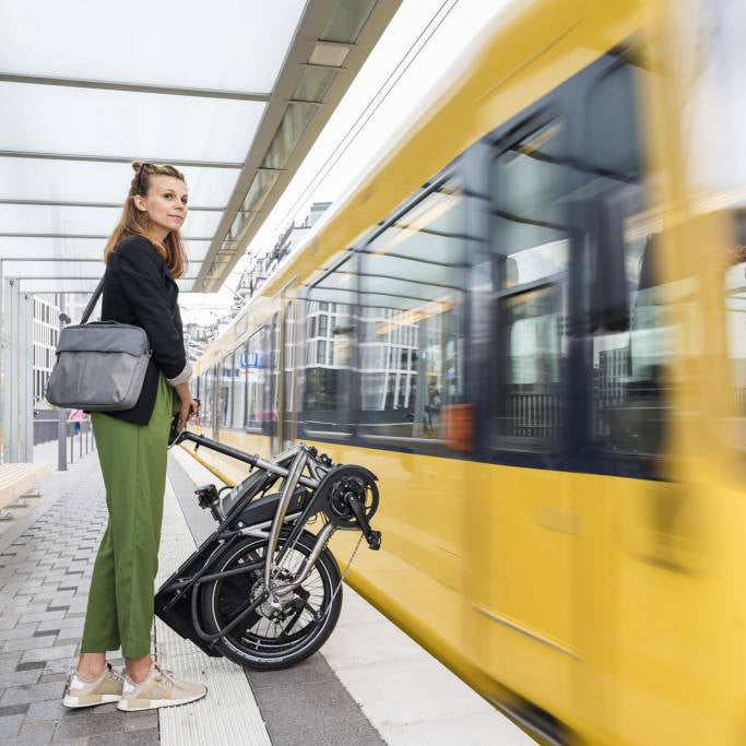 Woman with a Tern folded bike waiting at a train station