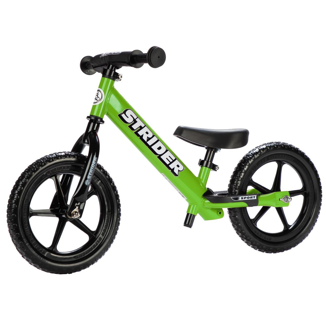 Green Strider balance bike on a white background
