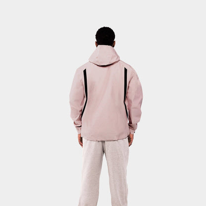 Person wearing a light pink jacket and beige pants on a white background