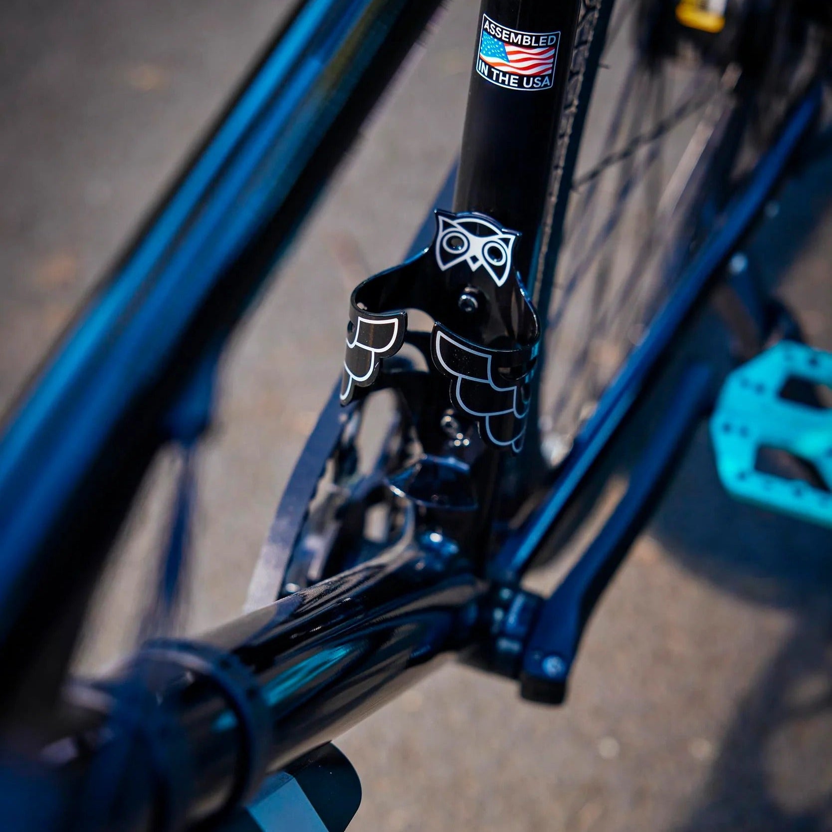 Close-up of a bicycle frame with a visible brand logo on a blurred road background
