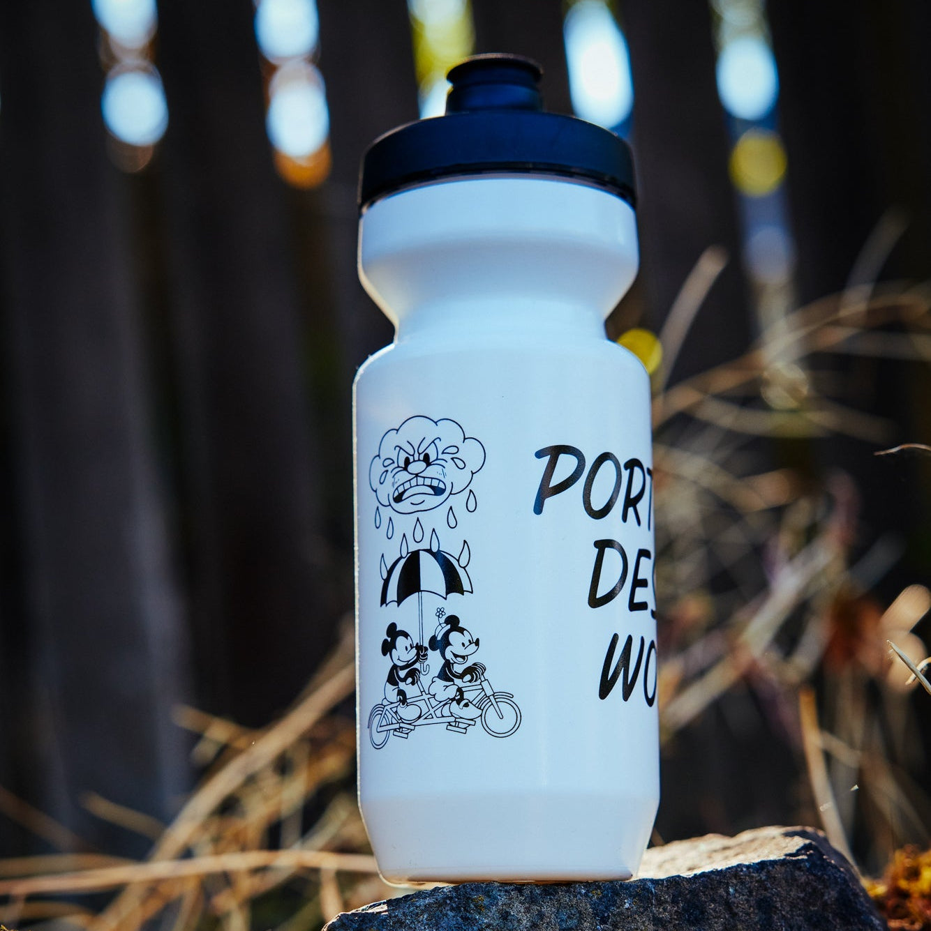 White water bottle with black text and graphics on a natural background