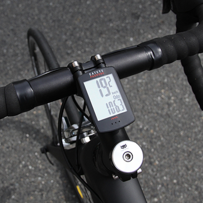 Bicycle handlebar with digital speedometer on a road background
