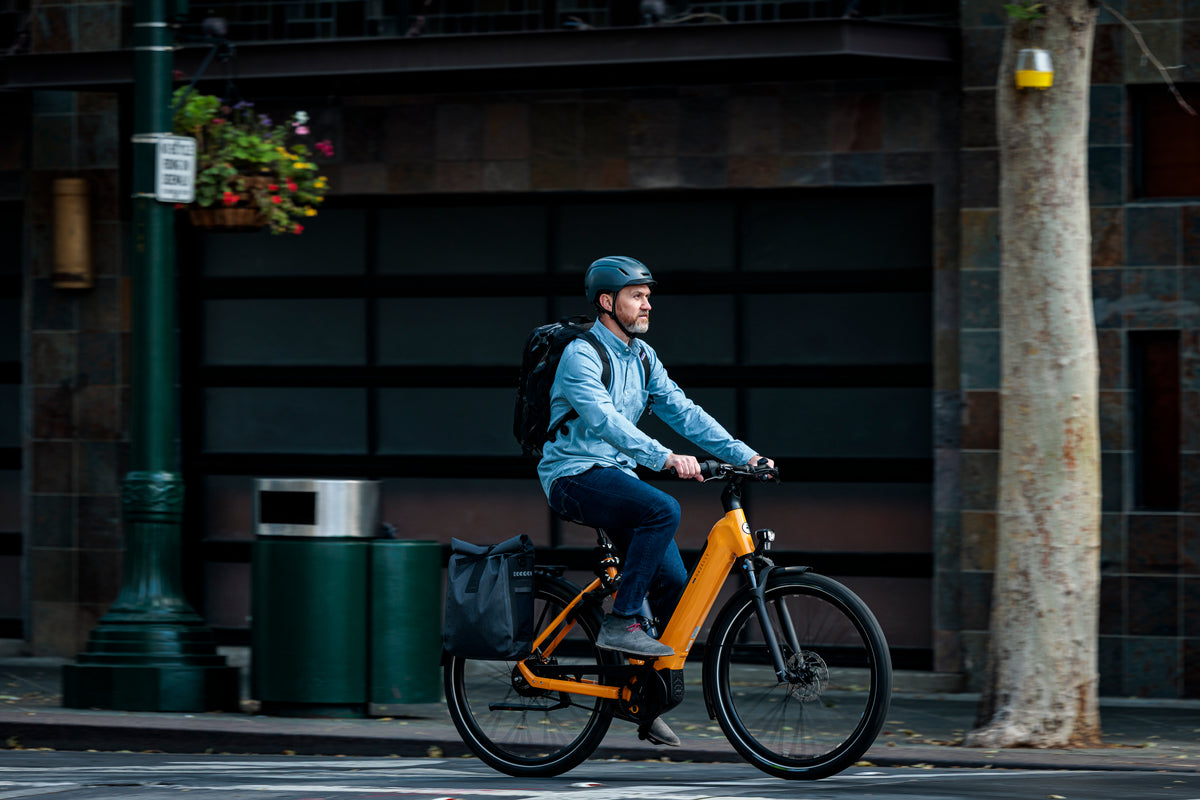 Rider commuting through downtown Portland on a yellow Gazelle Medeo e-bike