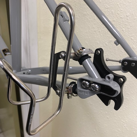 Bicycle water bottle holder attached to a bicycle frame against a neutral background