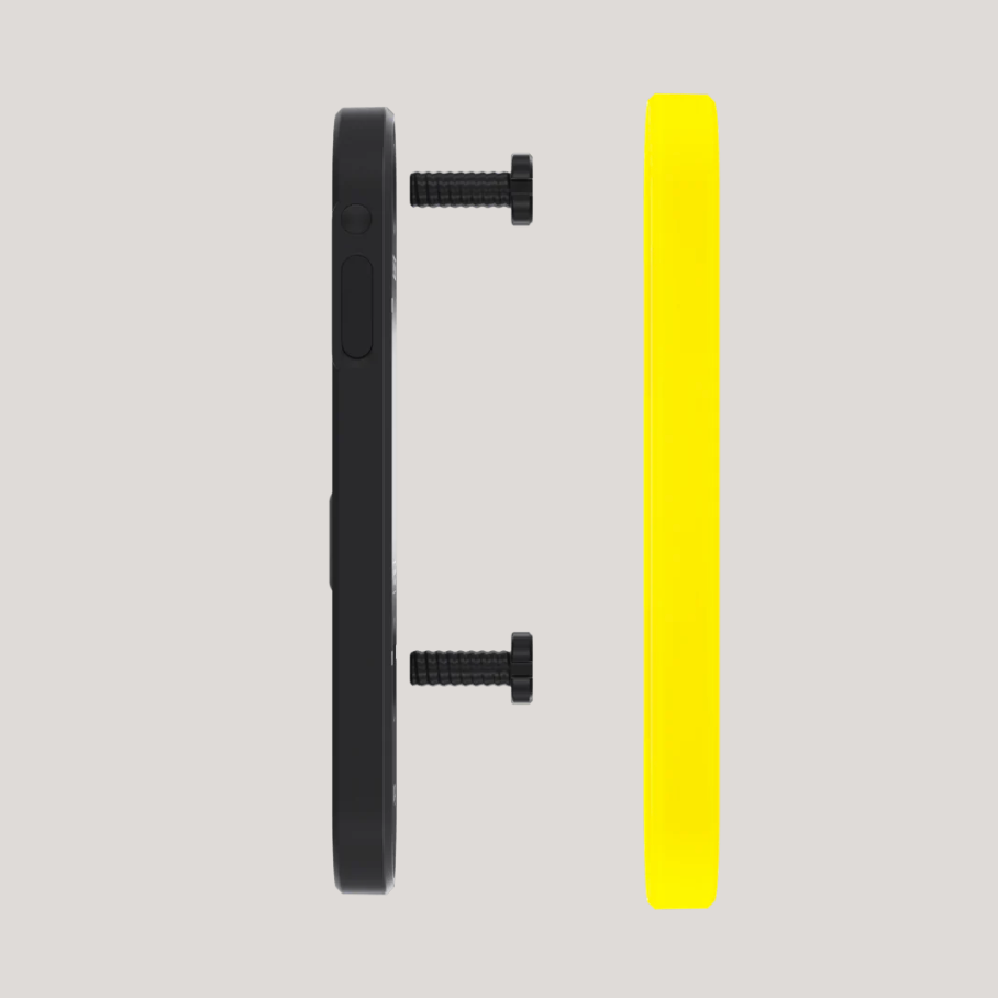 Black circular component with screws and a yellow rectangular object on a gray background