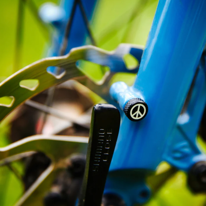 Close-up of a bicycle's disc brake system with a blue frame and peace symbol emblem.