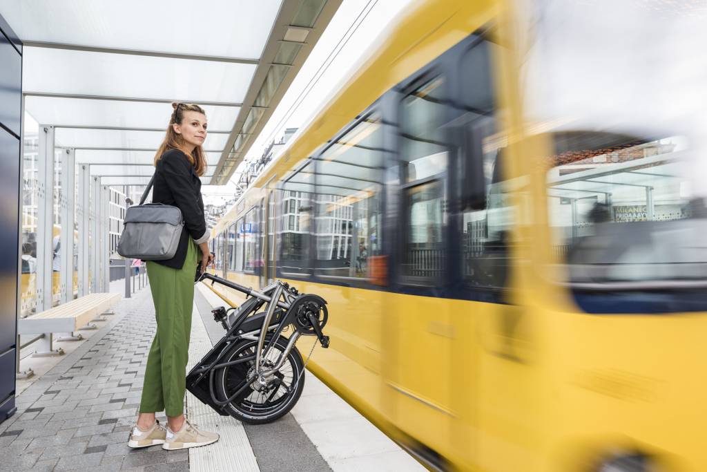 Woman with a Tern folded bike waiting at a train station