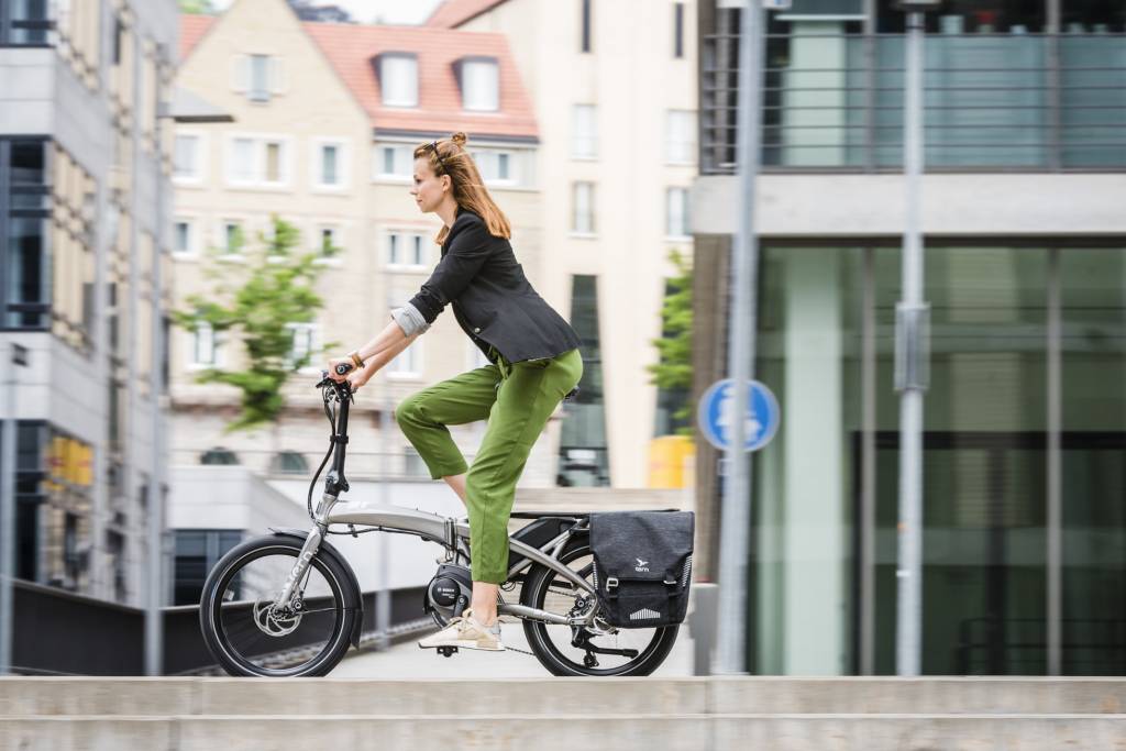 Woman riding a Tern folding electric bike in an urban setting